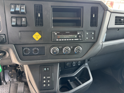 Kenworth T380 cab interior dashboard view showing HVAC controls, radio, ventilation vents, and storage compartments.