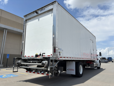 Kenworth T380 refrigerated truck rear view showing roll-up cargo door and trailer undercarriage.