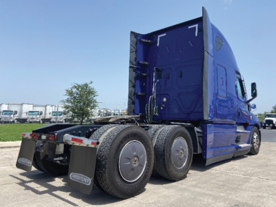 Freightliner Cascadia125/126 tractor rear view showing blue sleeper cab and dual rear axles with mudflaps and fifth wheel, stock number 557340.