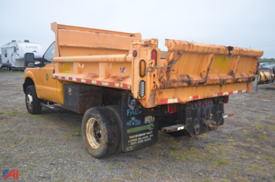 Dump truck bed and rear view of a yellow Ford F-350 Super Duty dump truck showing tailgate, hydraulic system, and taillights.
