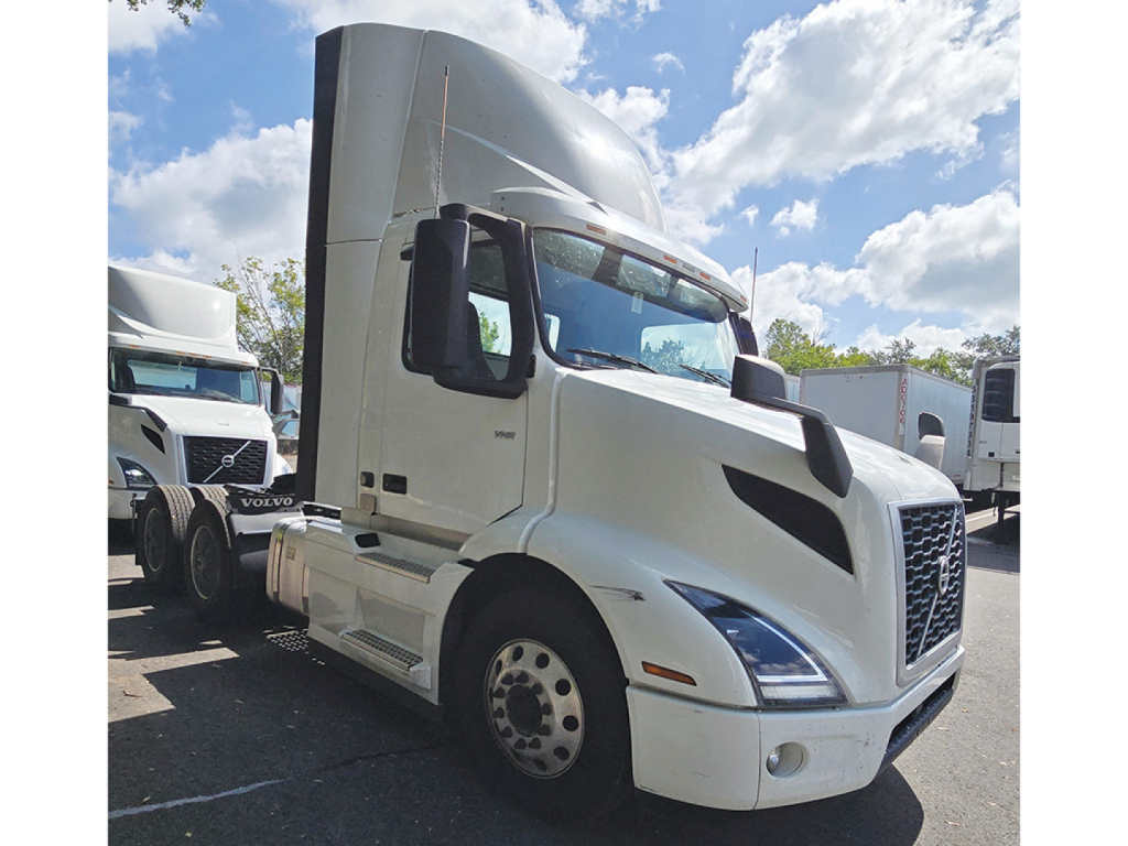 2022 Volvo VNR 300 conventional daycab truck side view showing white cab, large grille, and Volvo badge.