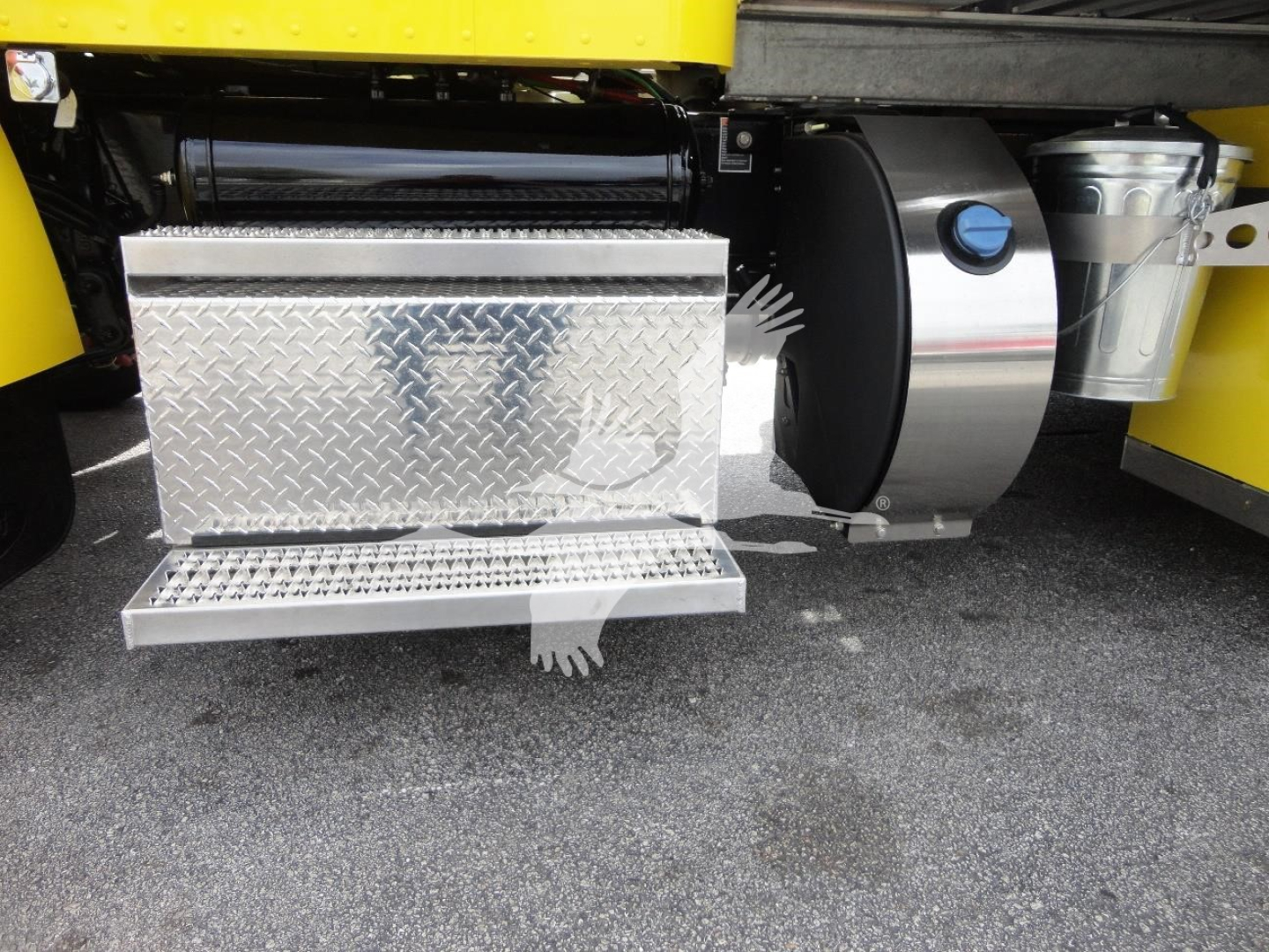 Truck side showing aluminum diamond-plate toolbox and fuel tank under a yellow Peterbilt 337.