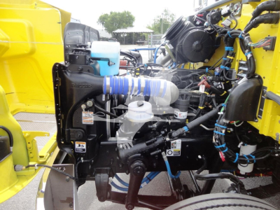 Tractor engine bay of a 2022 Peterbilt 337 rollback truck showing coolant reservoir, hoses, and various engine components.