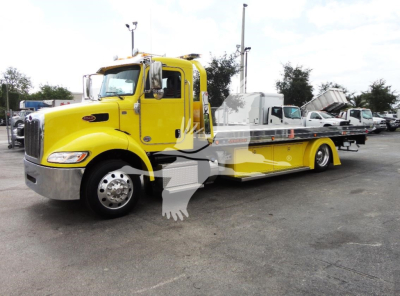 Peterbilt 337 rollback wrecker in yellow with extended flatbed and chrome front bumper.