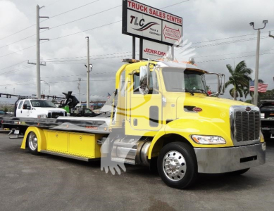 Peterbilt 337 rollback truck in bright yellow, front three-quarter view, with long wheelbase and flatbed for heavy towing.