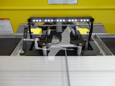 Truck bed winch assembly with LED light bar mounted above, cable and pulleys visible in foreground, yellow body in background.