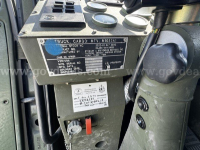 Truck cargo MTU M1083A tag plate with serial numbers and gauges in view inside cab area.