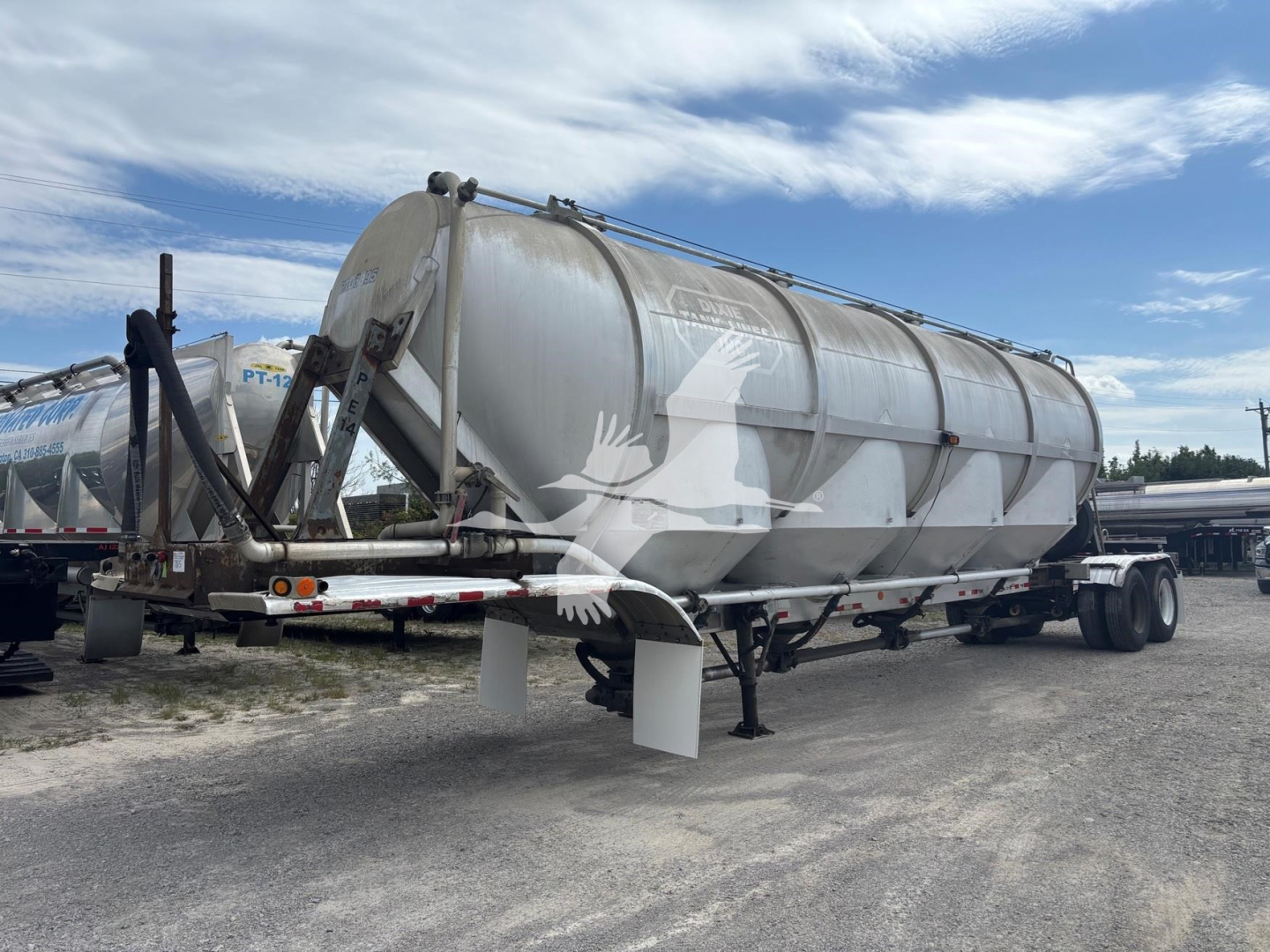 Pneumatic dry bulk trailer showing Polar 1660, weathered cylindrical tank, rear double-axle undercarriage, loading chutes, and support legs visible.