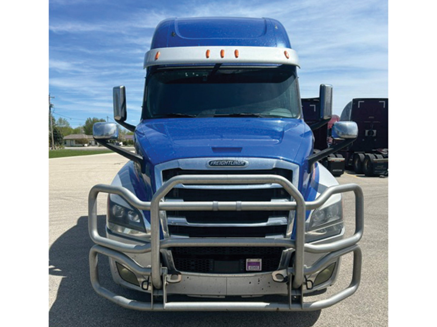 Front view of a blue 2021 Freightliner Cascadia 126 sleeper axle showing grille guard and chrome bumper guard.