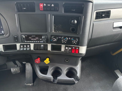 Kenworth T680 dash area showing center console with two cup holders, ignition area, controls, and empty screen slot.