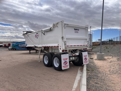 Ranco quarter frame steel end dump trailer showing rear with loaded container and dual rear axles.