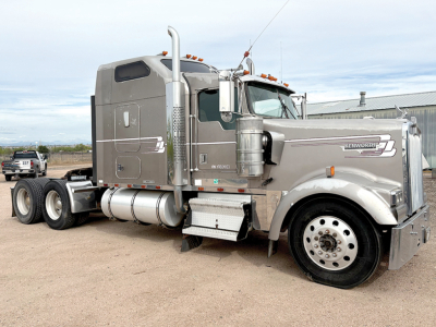 Kenworth W-900L AeroCab conventional sleeper truck side view showing chrome fuel tanks, air filters, and large exhaust stack with raised grille and hood ornament.