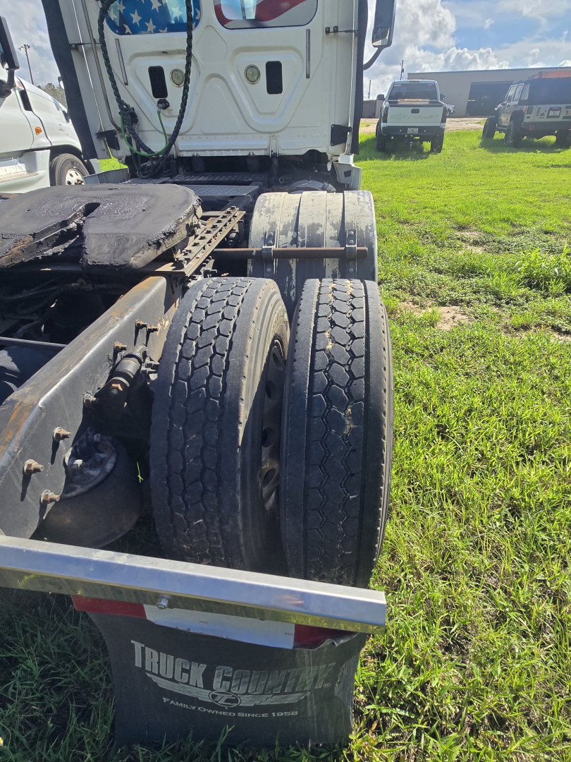 Truck chassis rear showing dual rear axles with tires and fifth wheel view, Freightliner Cascadia 125 in used condition.