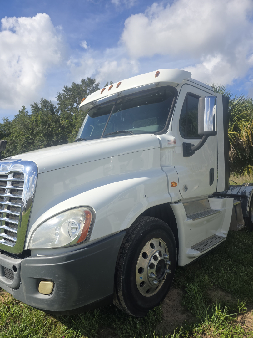 Truck cab side view showing 2017 Freightliner Cascadia 125 day cab with white exterior and front left angle.