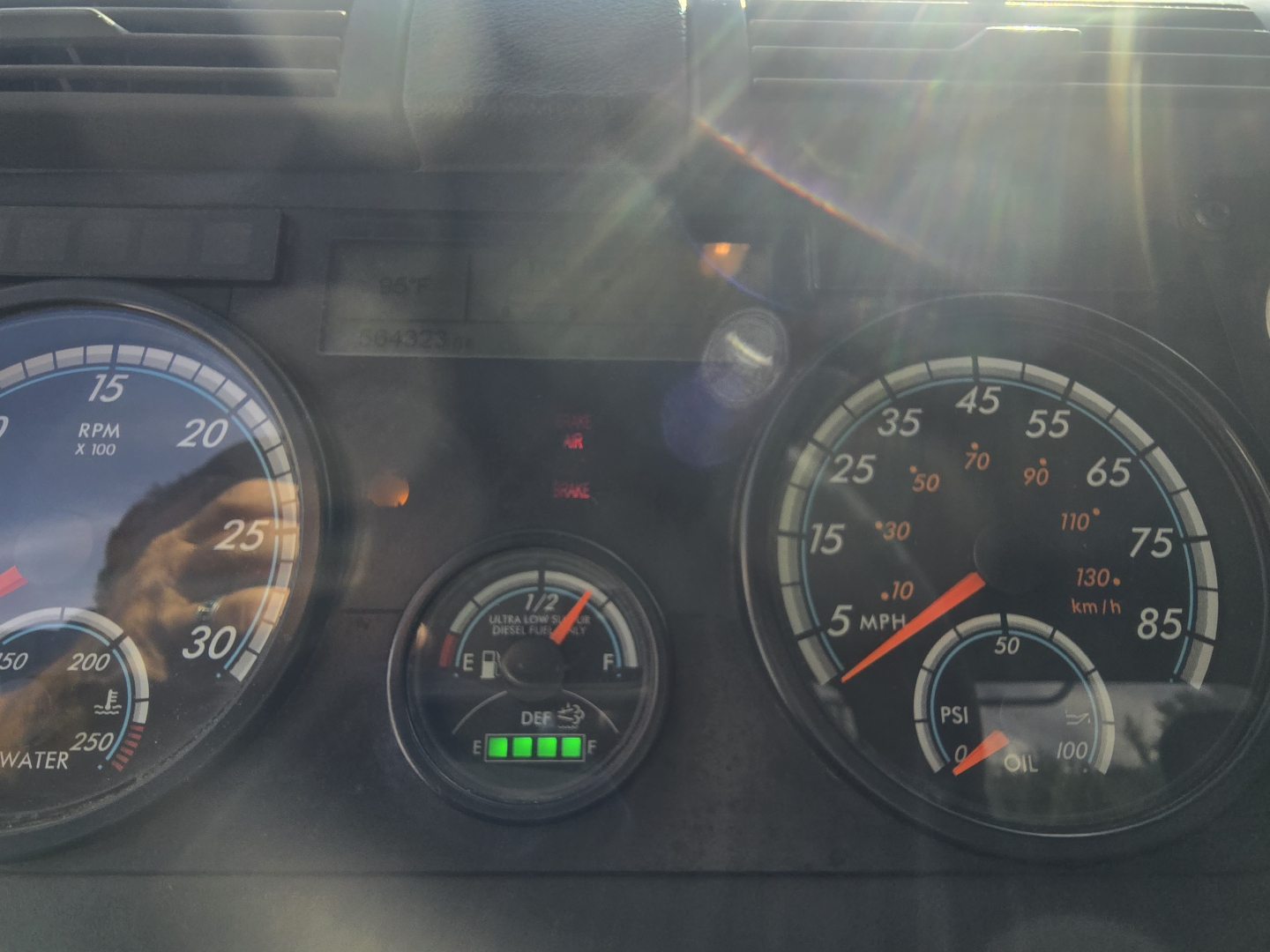 Dashboard cluster of a Freightliner Cascadia showing RPM gauge, coolant temp, fuel gauge, and speedometer with marked psi and mph readings.