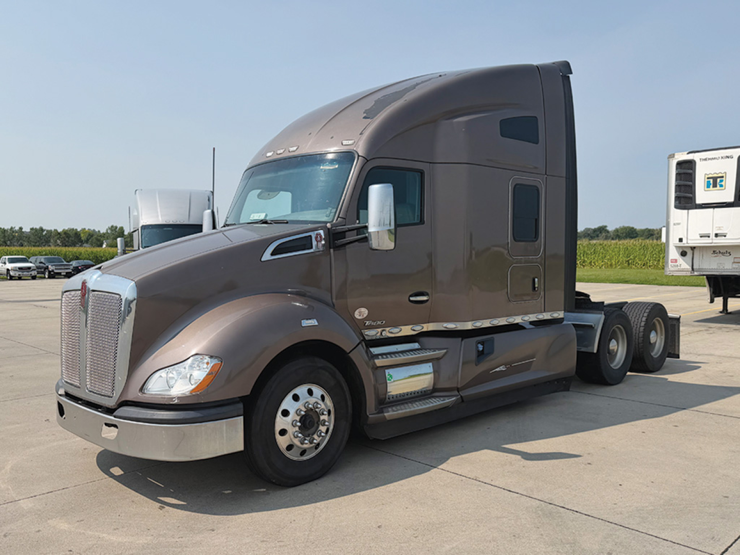 Kenworth T680 tractor unit in service showing aerodynamic cab with sleeper, side chrome mirrors, fuel tanks, and 6 wheels on drive axle.