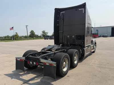 Kenworth T-680 tractor rear view showing fifth wheel and dual rear axles with mud flaps and fuel tanks