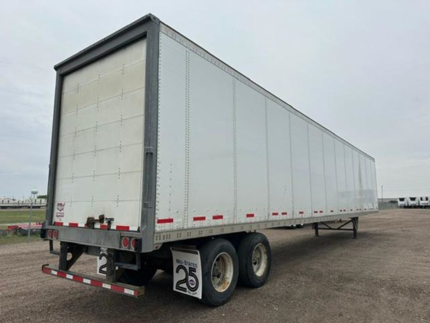 Trailer showing rear and side of a white 2016 Wabash van trailer with dual rear tires and stock number U90916.