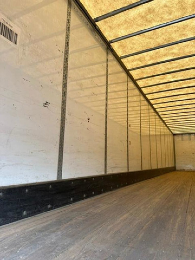 Trailer interior showing cargo area with wooden floor and side walls, no visible branding or labels clearly legible.