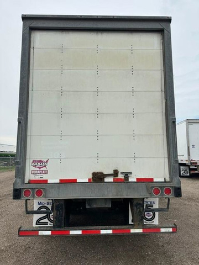 Rear view of a 2016 Wabash trailer van showing closed roll-up door, rear bumper, taillights, and registration plate area.