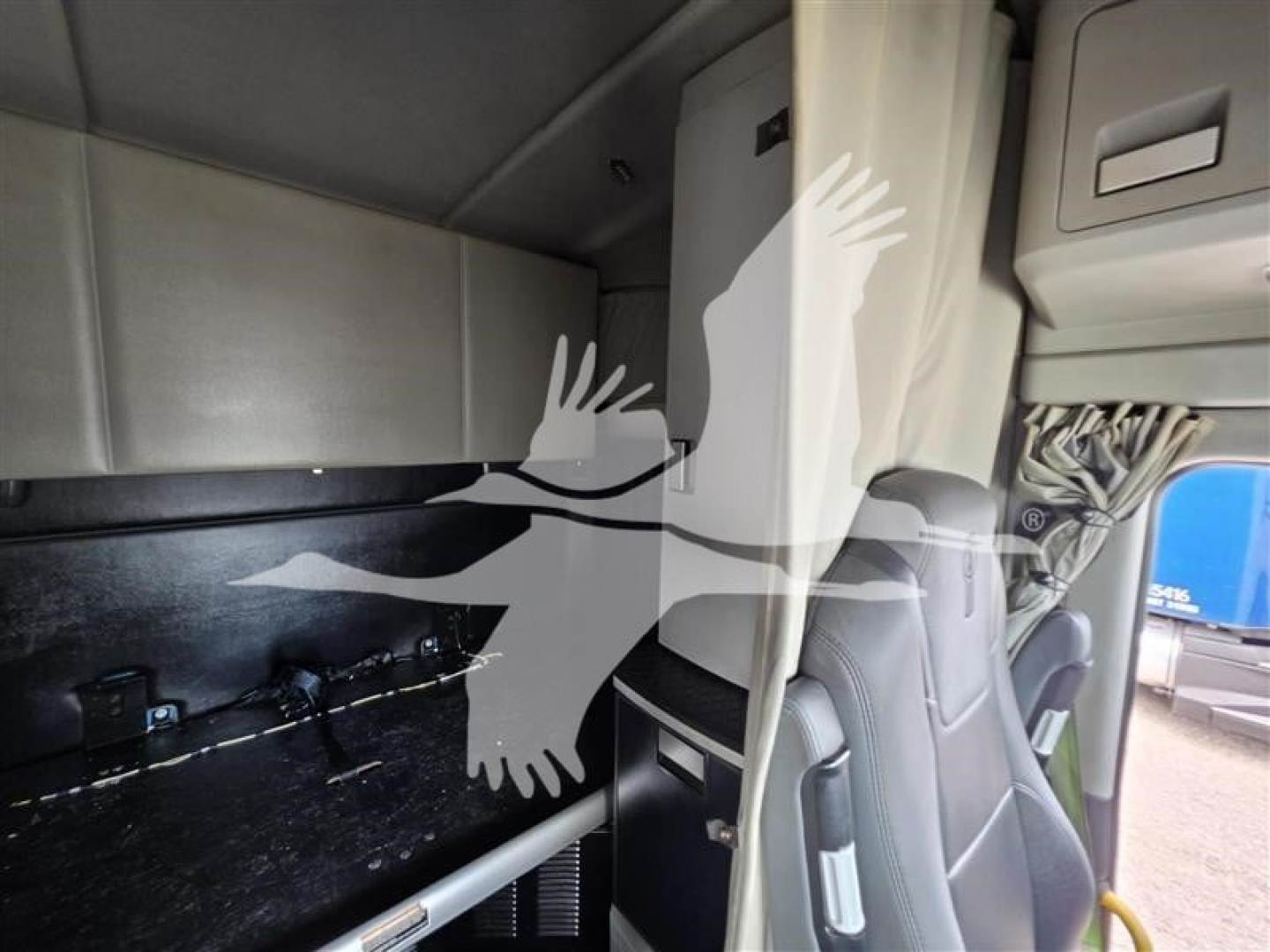 Kenworth T680 cab interior showing sleeper area and storage panel.