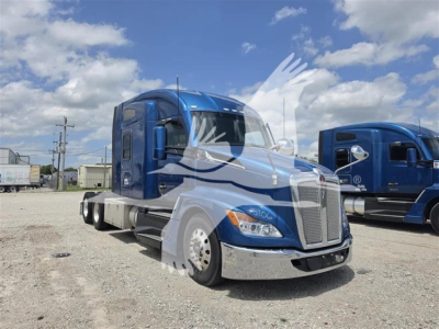 Kenworth T680 in blue, side view, sleeper cab, front grille, chrome bumper, dual rear axles, daytime outdoor lot.