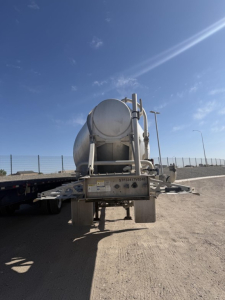 Heil pneumatic tank trailer rear view showing cylindrical tank and undercarriage with hitch and support beams.