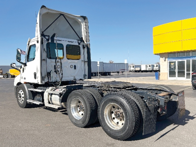 Truck chassis and cab of a Freightliner Cascadia 116 shown from side/rear angle, with dual rear axles and flatbed frame.