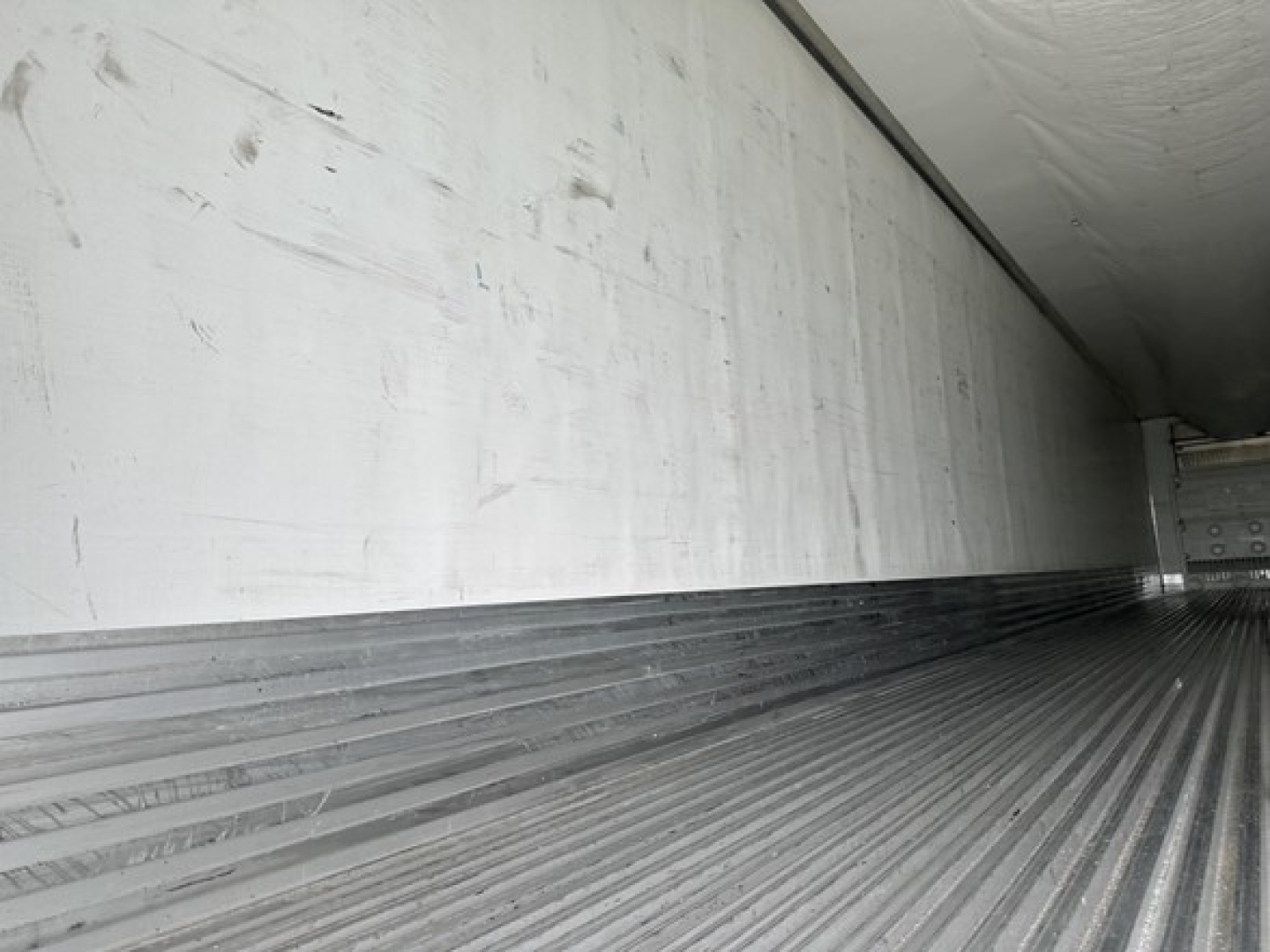 Trailer interior of a 2020 Utility 3000R reefer showing corrugated metal floor and side wall with underside of ceiling panels.
