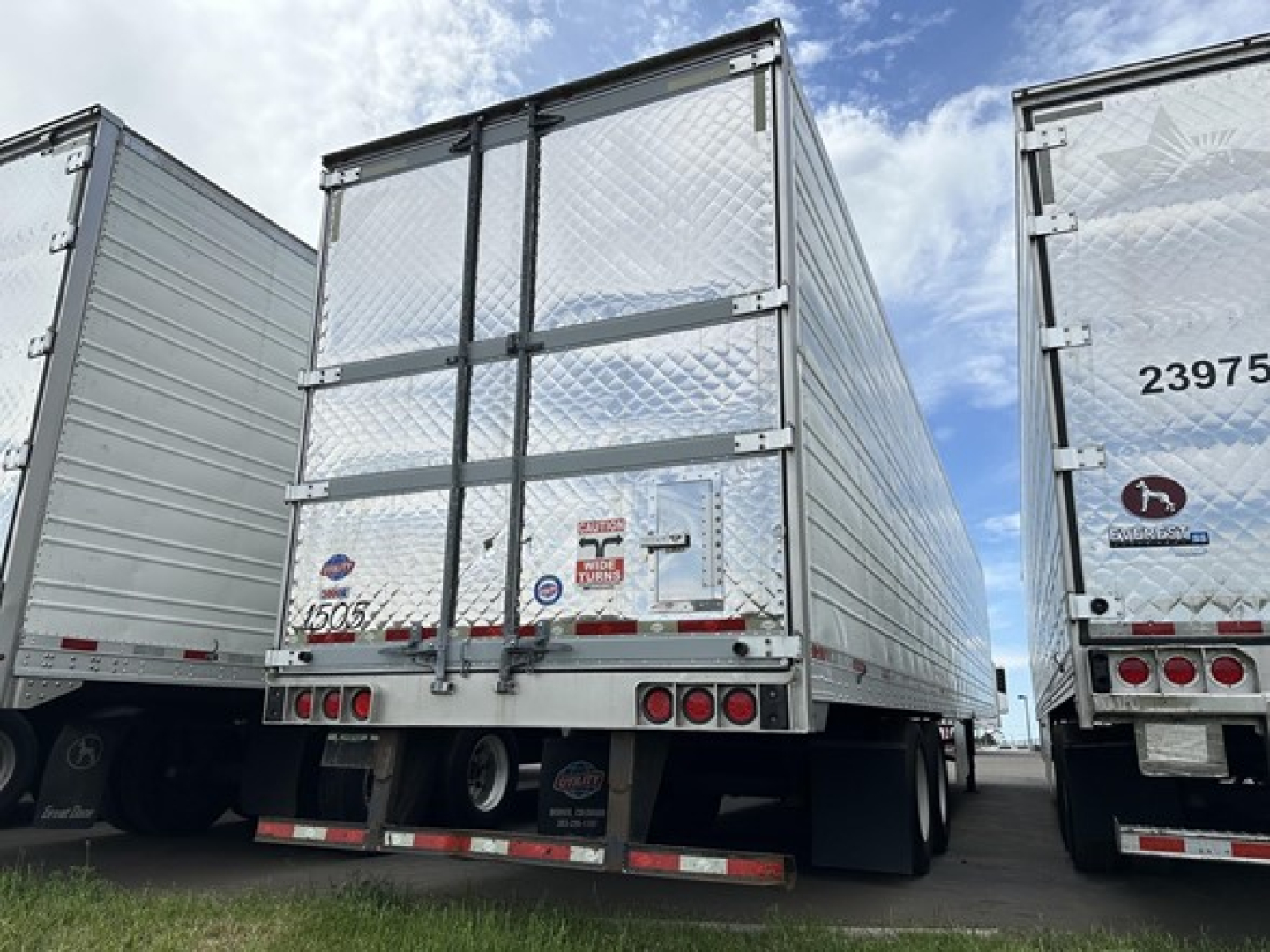 Trailer rear view showing aluminum reefer trailer with diamond plate doors and taillights.
