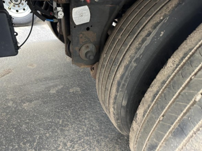 Trailer wheel area of a 2020 Utility 3000R with dual rear axles, showing the dual tires, suspension hanger, and a rust-colored mounting bracket.