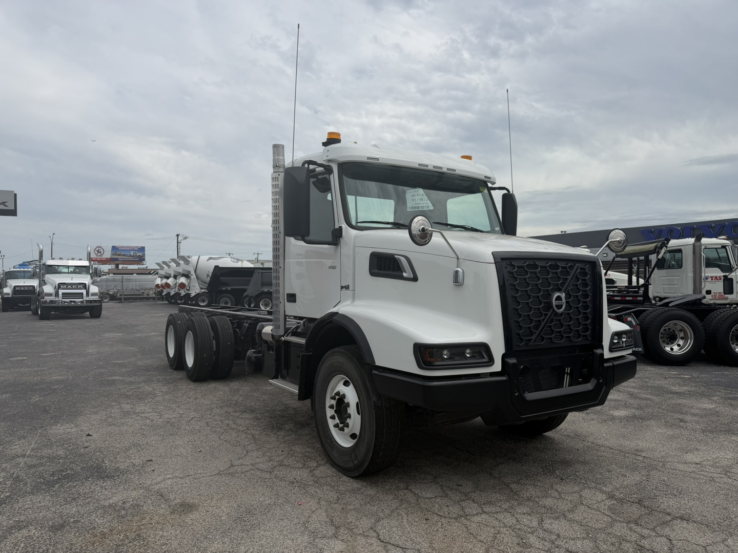 Volvo VHD86B300 cab and chassis truck in a dealership lot showing front view with grille and cab, white exterior.