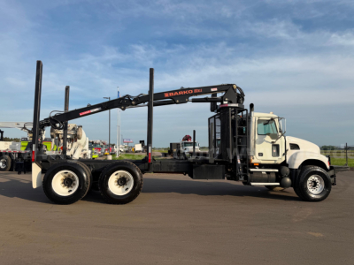 Mack CV713 truck with long reach crane attachment and tall outrigger posts, side view showing grapple truck.
