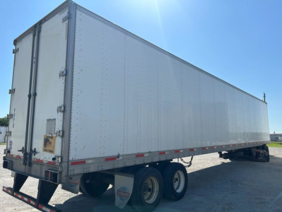 Trailer with box body showing rear doors, dual rear axles, side of long box trailer.