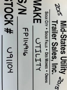 Vertical trailer sign showing 'Mid-States Utility Trailer Sales, Inc.' and text: '2015' and 'Stock #' with handwritten 'FTLY' and 'FP1496' along with location list Sioux City, Sioux Falls, Des Moines, Omaha.