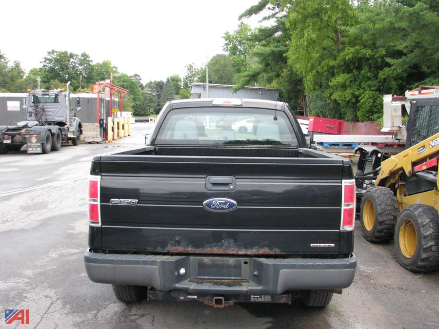 Ford F-150 tailgate view showing 4x4 badge and hitch receiver with Ford oval logo; black truck bed and taillight assemblies visible.
