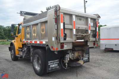 Dump truck bed of a 2014 Freightliner M2 106 Dump Truck viewed from rear-left showing lettering and rear equipment.
