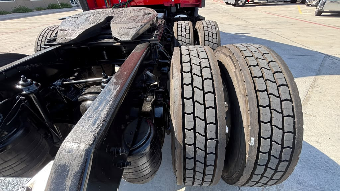 Kenworth T680 chassis showing dual rear axles with tires and suspension components; no cab, view of fifth wheel area and frame rails.