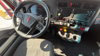Kenworth T680 semi-truck interior dashboard and steering wheel with controls and gauges visible.