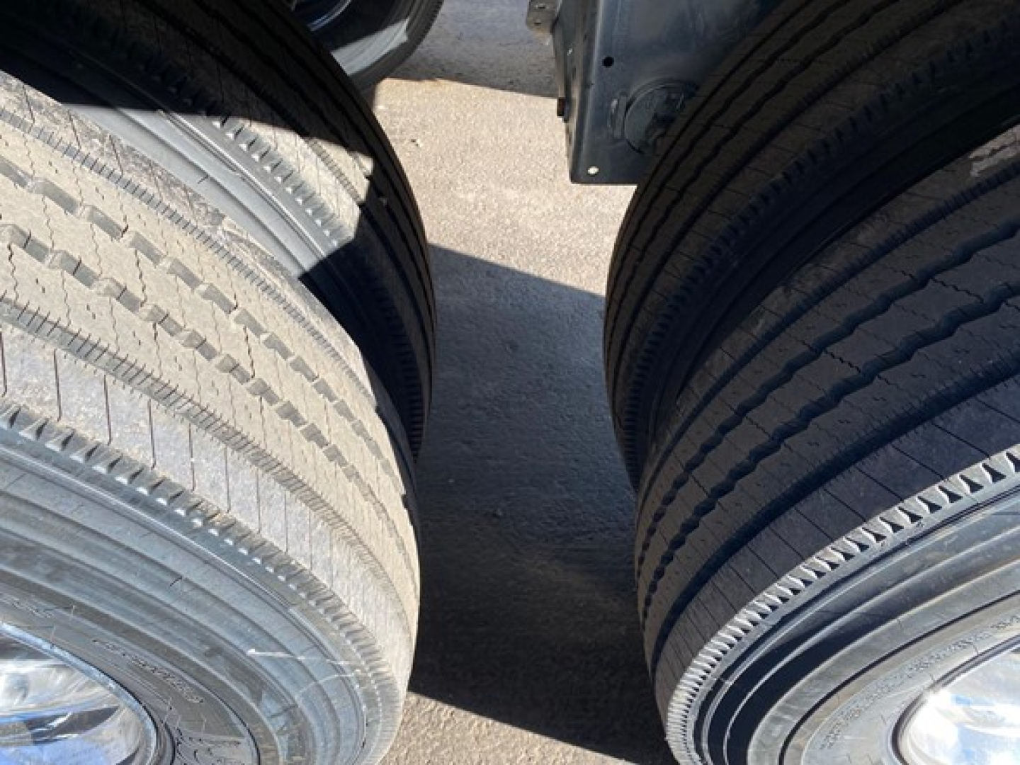 Dual rear truck tires mounted on a Mac Macsimiser 1/2 Round trailer showing tread patterns and wheel wells.