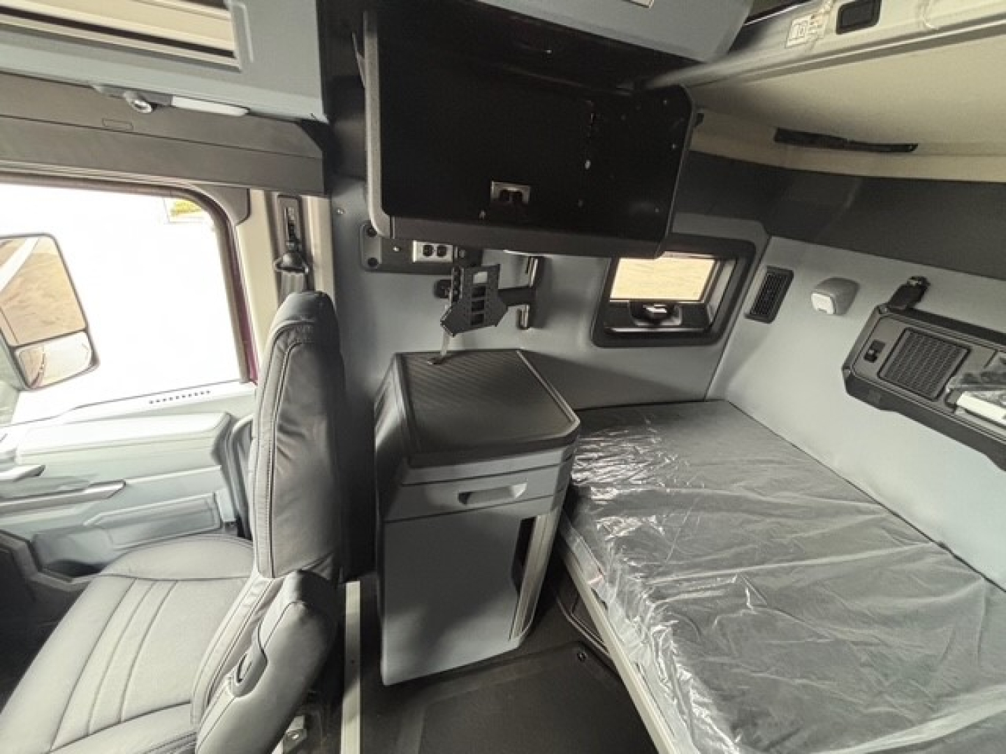 Mack PR64T76H truck cab interior view with sleeper berth and control console.