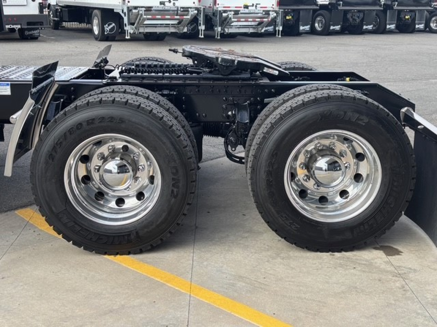 Dual rear wheels on a Mack PR64T76H tractor chassis showing chrome wheel hubs and tires with visible frame rails and fifth wheel area.