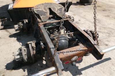 Rear view of a Freightliner Cascadia 125 chassis with chain hoist, exposed frame, suspension components, and a rust-colored rear frame.