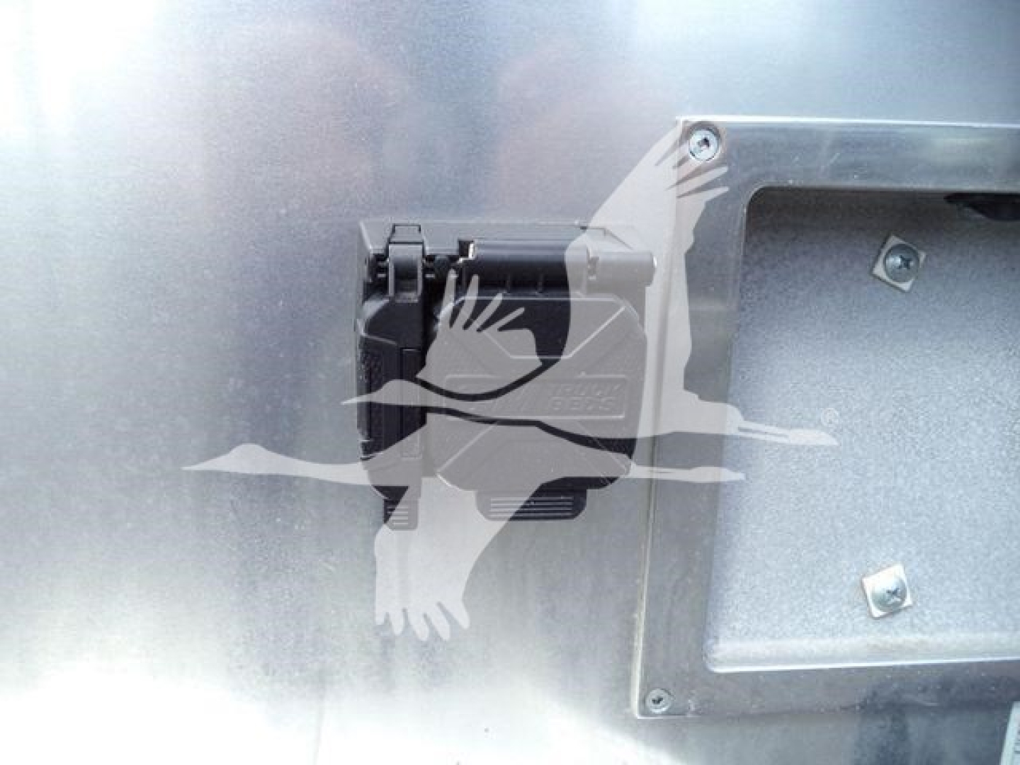 Close-up of a Ram 5500 engine bay area with a black plastic component and metal panel; no legible text visible.