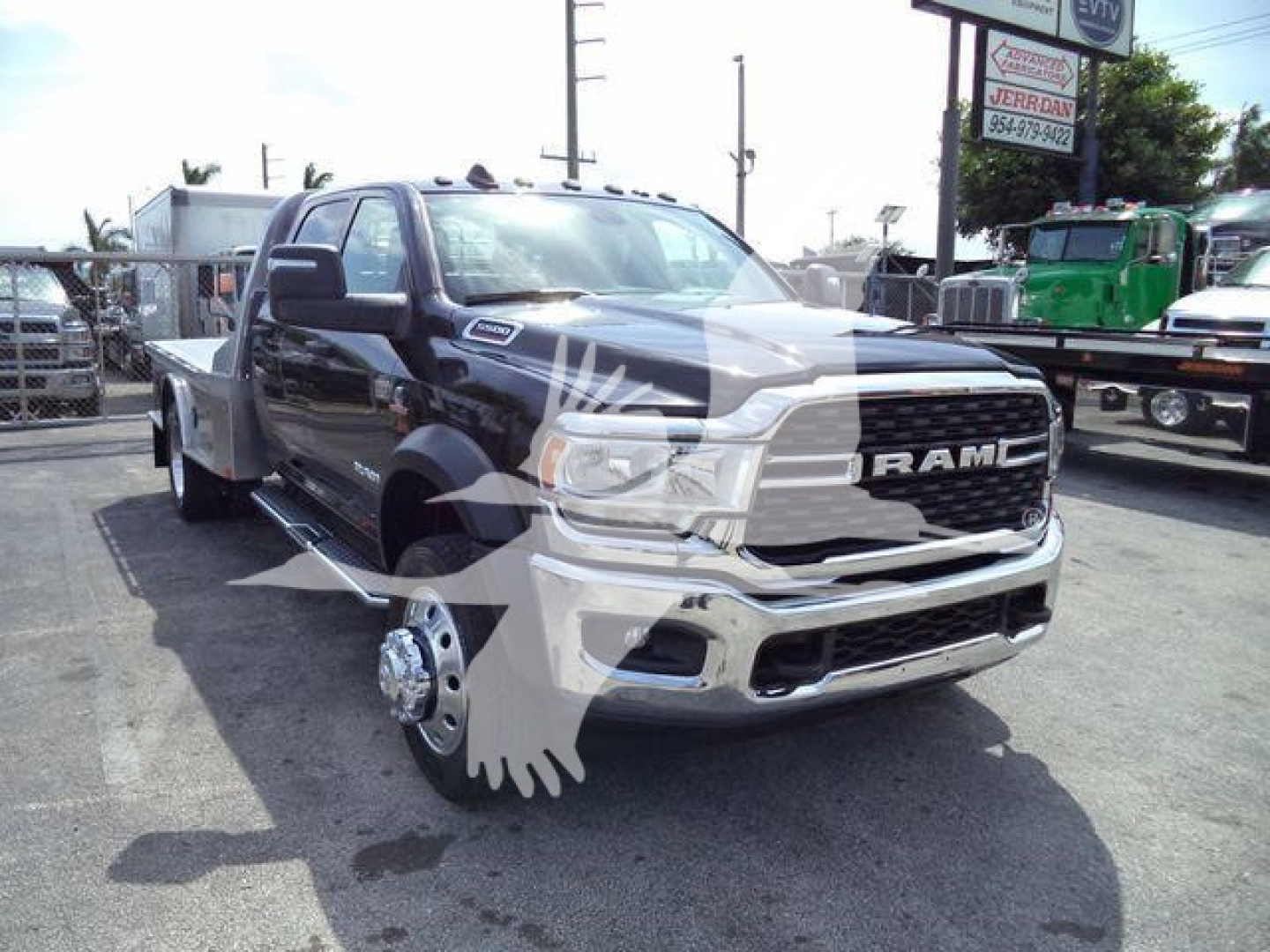 Ram 5500 SLT flatbed truck front view showing RAM grille, chrome bumper, and dual rear wheels on a service lot.
