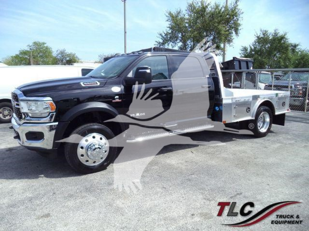 Ram 5500 SLT flatbed truck side view with black cab and silver utility bed in a dealership lot.