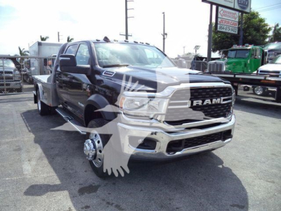Ram 5500 SLT flatbed truck front view showing RAM grille, chrome bumper, and dual rear wheels on a service lot.