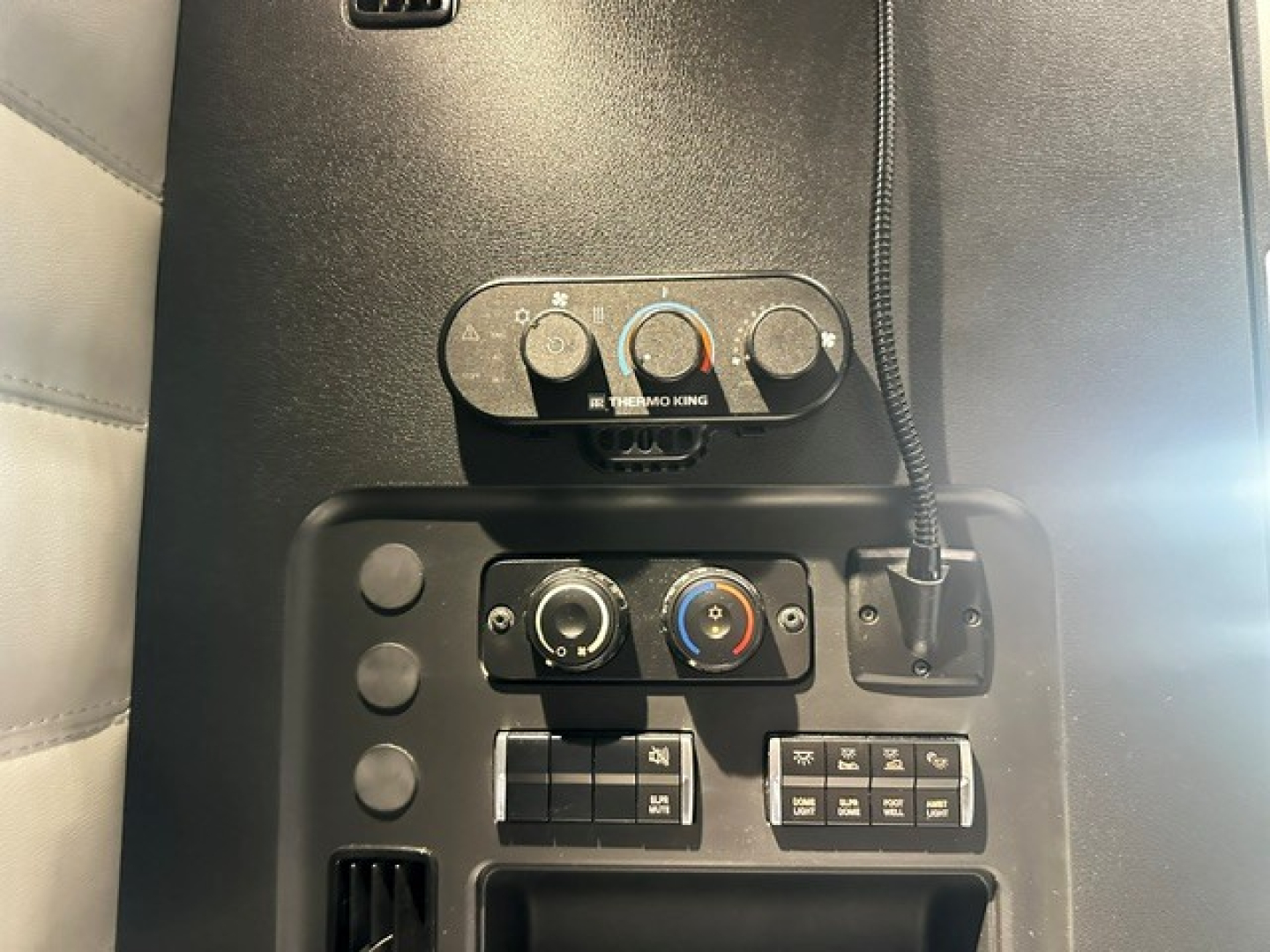 Cabin controls and climate panel of a Freightliner Cascadia 126 truck cab with HVAC knobs and switches visible.