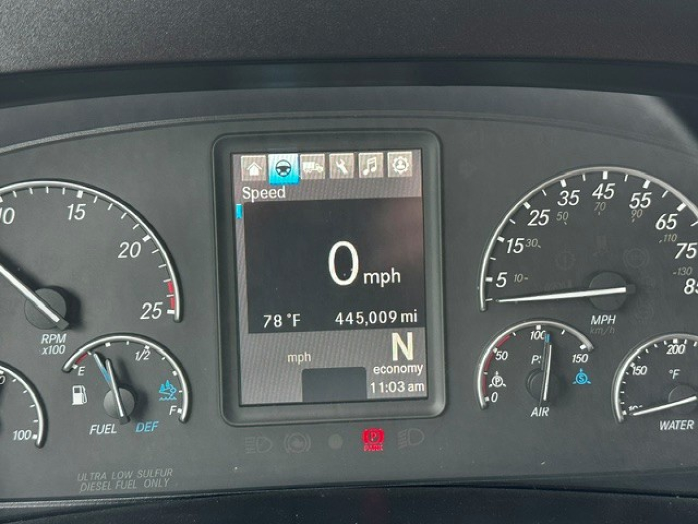 Dash cluster of Freightliner Cascadia 126 showing digital display reading 0 mph, 445,009 miles, temperature 78 F, gear N, and surrounding analog gauges.