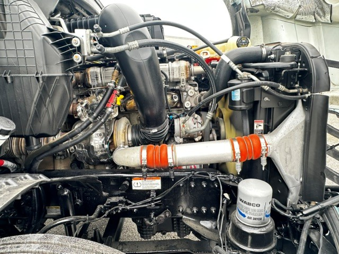 Engine bay of a 2023 Freightliner Cascadia 126 shown with hoses, turbo, oil filter, and various components visible.
